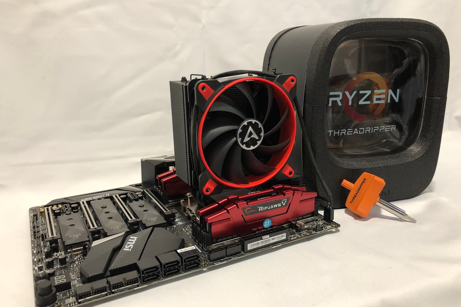 The first Threadripper build on a white sheet: MSI X399 board, red cooler fan, red memory
